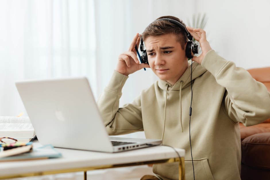 Learner listening carefully to English audio on a laptop