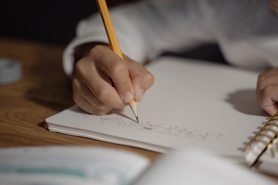 Student writing English pronunciation notes in a notebook